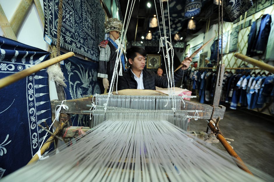 Craftsperson working with fabric using traditional workshop equipment.